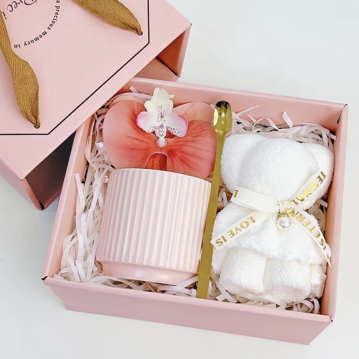 Blush pink ribbed ceramic mug gift set with gold spoon, silk orchid, and teddy bear towel in a Precious Gift box